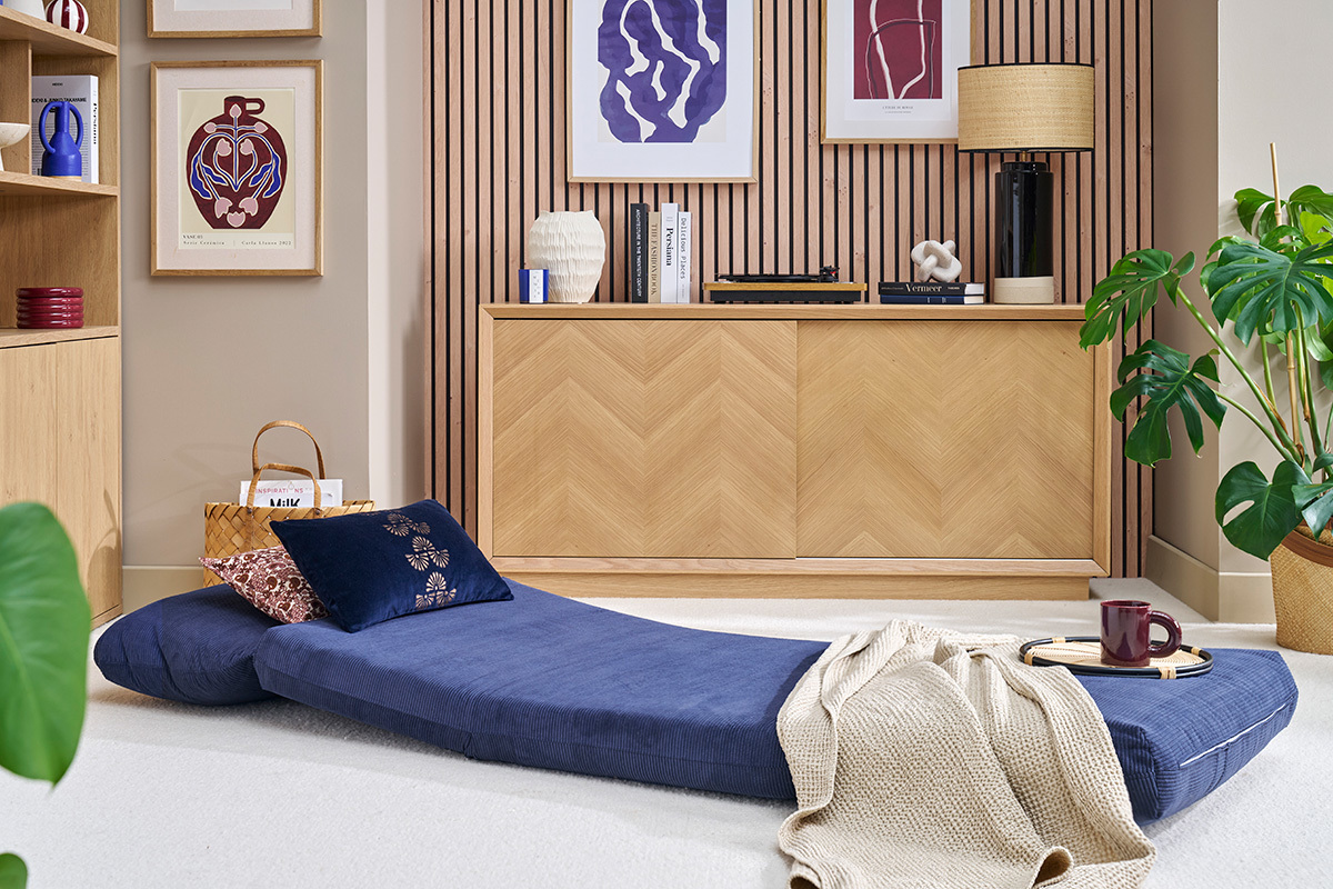 Chauffeuse convertible bleue SPENCER dplie dans un salon moderne.