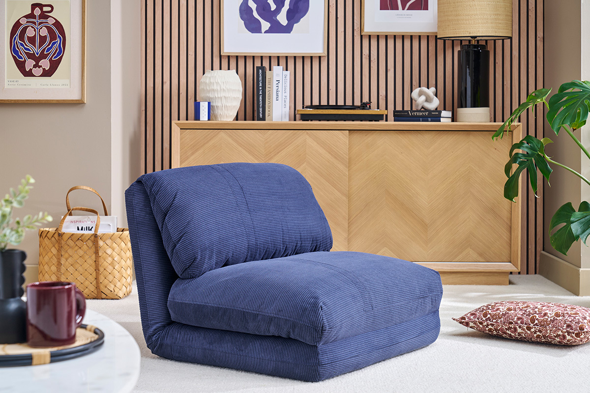 Chauffeuse convertible en velours ctel bleu fonc dans un salon moderne avec dcoration.
