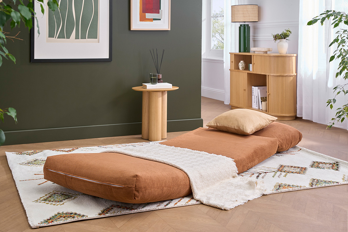 Chauffeuse SPENCER en tissu velours c�tel� terre br�l�e, d�pli�e dans un salon avec d�cor.