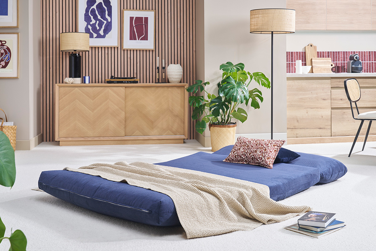 Chauffeuse convertible en velours bleu fonc dplie en lit, vue intrieure d'une pice.