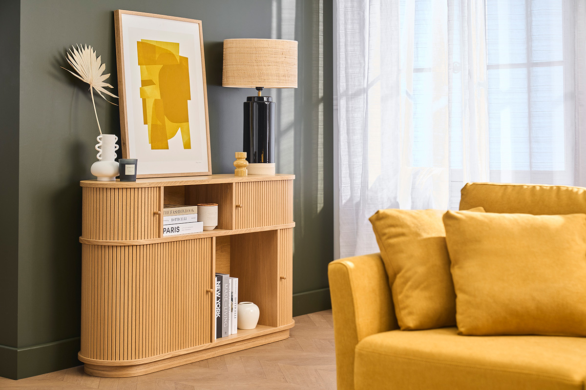 Console vintage en bois clair avec portes coulissantes, d�cor�e d'une lampe et d'un tableau.