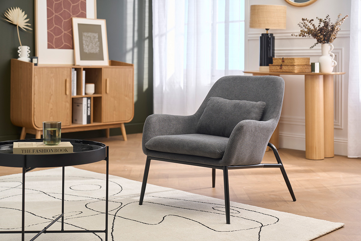 Fauteuil design en tissu velours gris fonc� et m�tal noir, angle 3/4, dans un salon moderne.