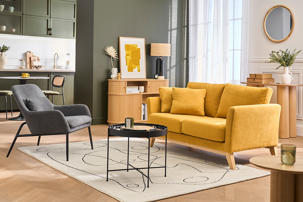 Fauteuil gris fonc� en tissu effet velours avec pieds en m�tal noir, dans un salon moderne.