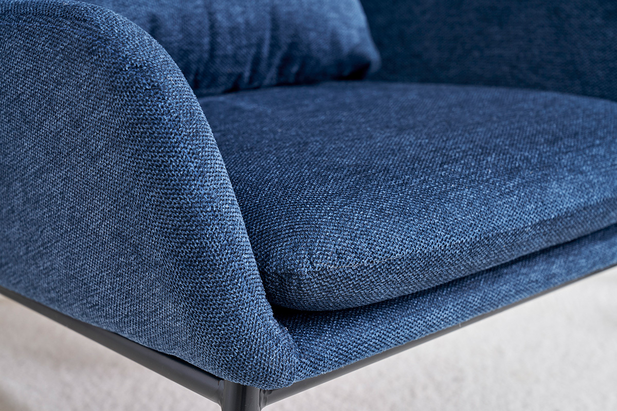 Dtail du tissu effet velours textur bleu fonc d'un fauteuil avec structure en mtal noir.