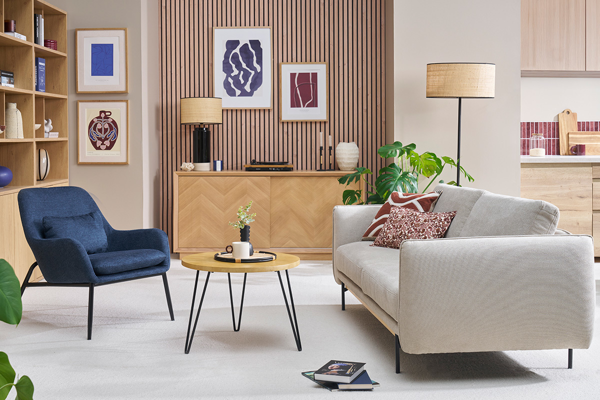 Fauteuil bleu fonc en tissu effet velours avec pieds en mtal noir, dans un salon moderne.