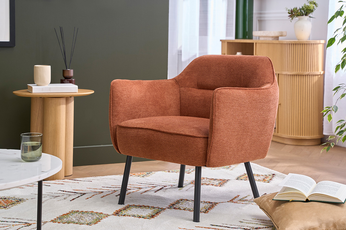 Fauteuil en tissu terre br�l�e avec pieds en m�tal noir, vue de trois quarts dans un salon moderne.