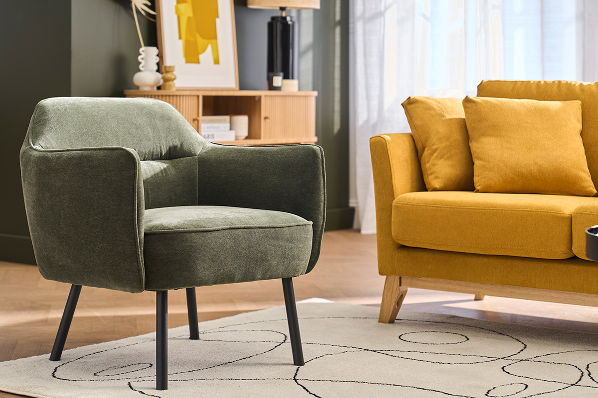 Fauteuil en velours vert kaki avec pieds en m�tal noir dans un salon.
