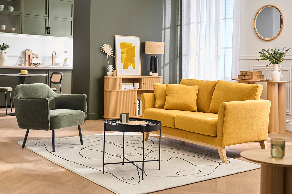 Fauteuil en tissu vert kaki et m�tal noir dans un salon moderne avec canap� jaune et table basse.