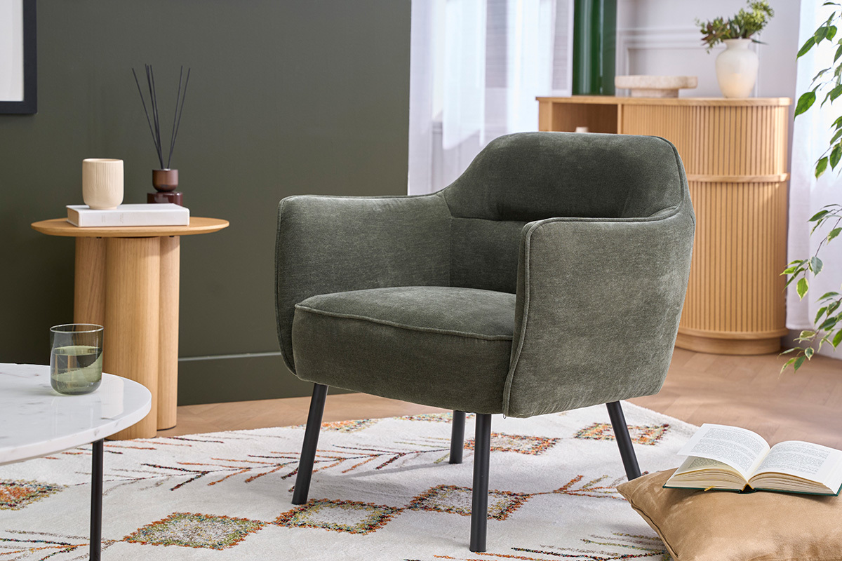 Fauteuil design velours vert kaki et m�tal noir dans un salon, vue de 3/4.