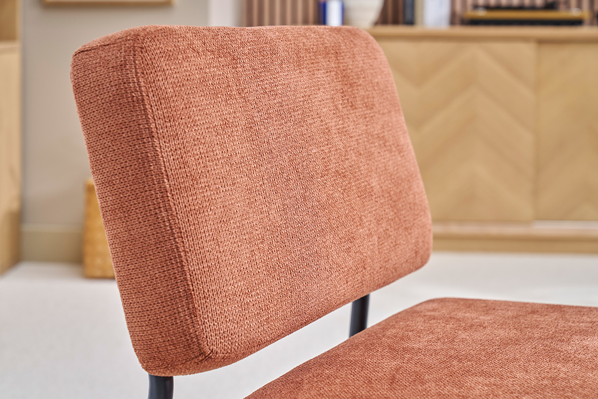 Gros plan sur le dossier du fauteuil VEDANA en tissu chenille terre brle et mtal noir.