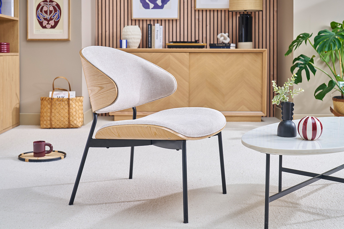 Fauteuil beige en tissu effet velours, bois clair et mtal noir dans un salon moderne.