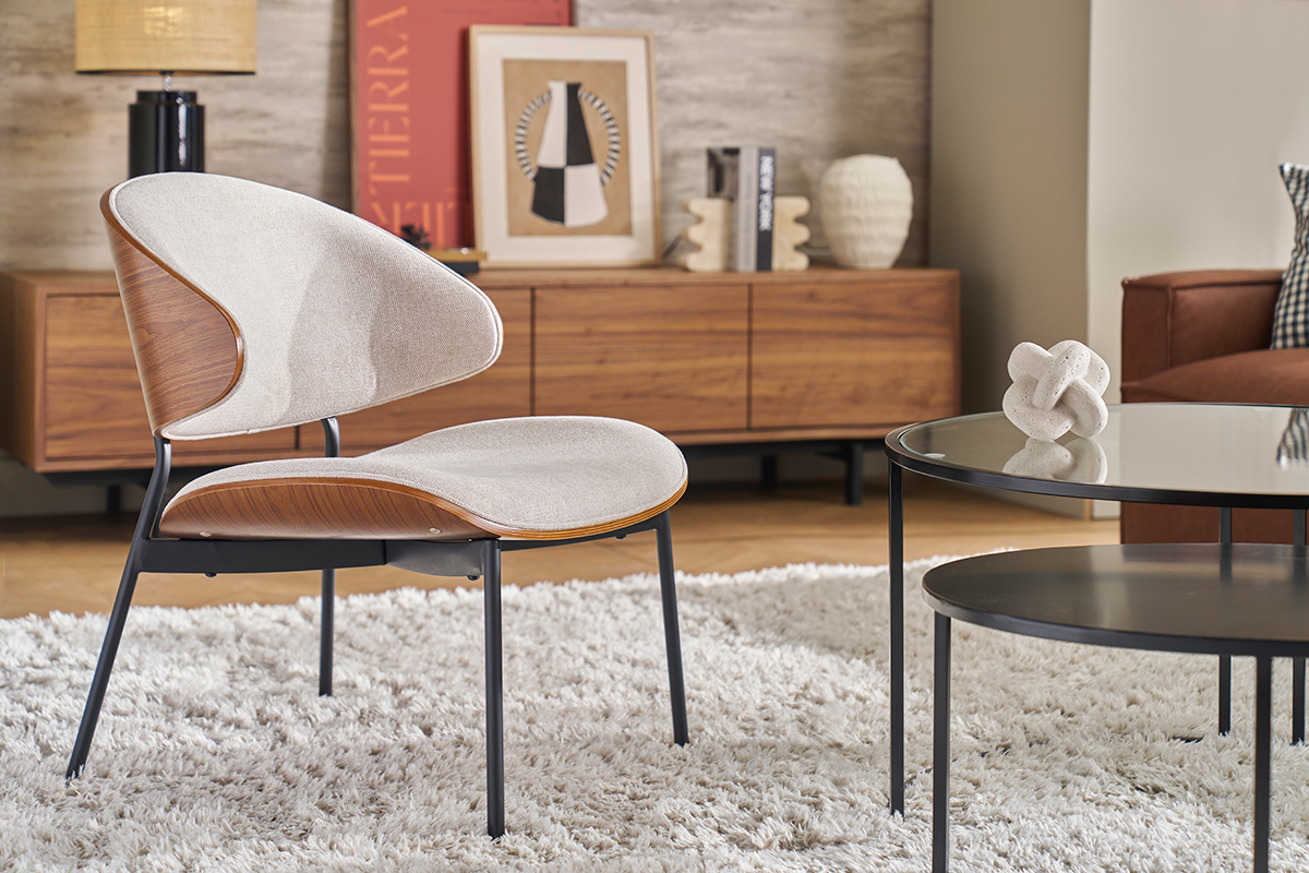 Fauteuil beige en tissu effet velours, bois fonc et mtal noir dans un salon moderne.