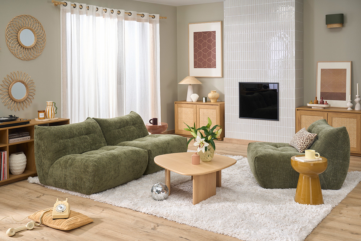 Fauteuil lounge BUMPY en tissu vert kaki, vue en angle avec table basse et autres meubles dans un salon moderne.