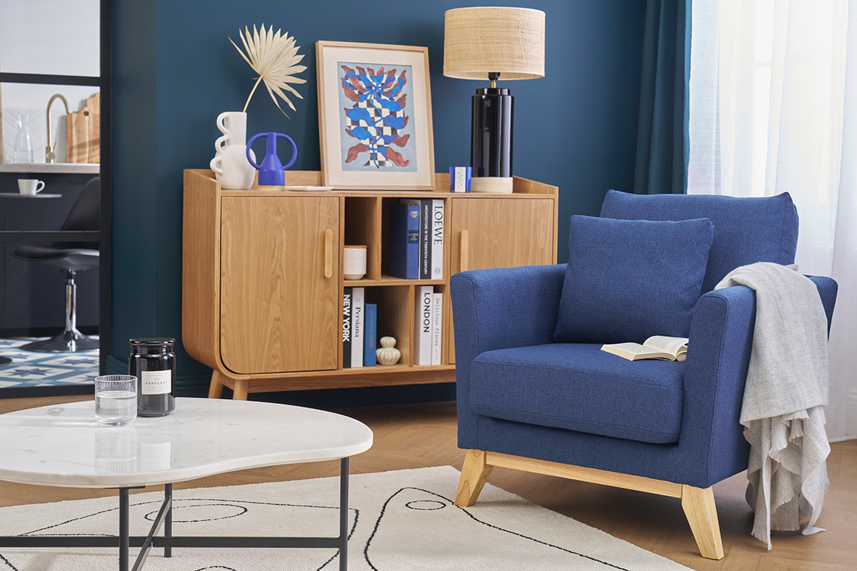Fauteuil scandinave bleu fonc et bois clair dans un salon moderne.