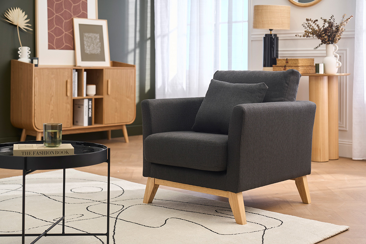 Fauteuil scandinave gris fonc� et bois clair OSLO, vue de trois quarts dans un salon.