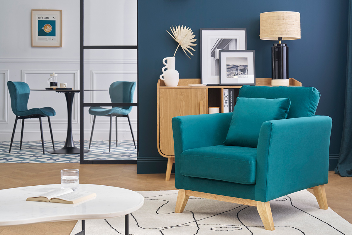 Fauteuil scandinave bleu en velours avec pieds bois clair, vue de face, dans une pice moderne.