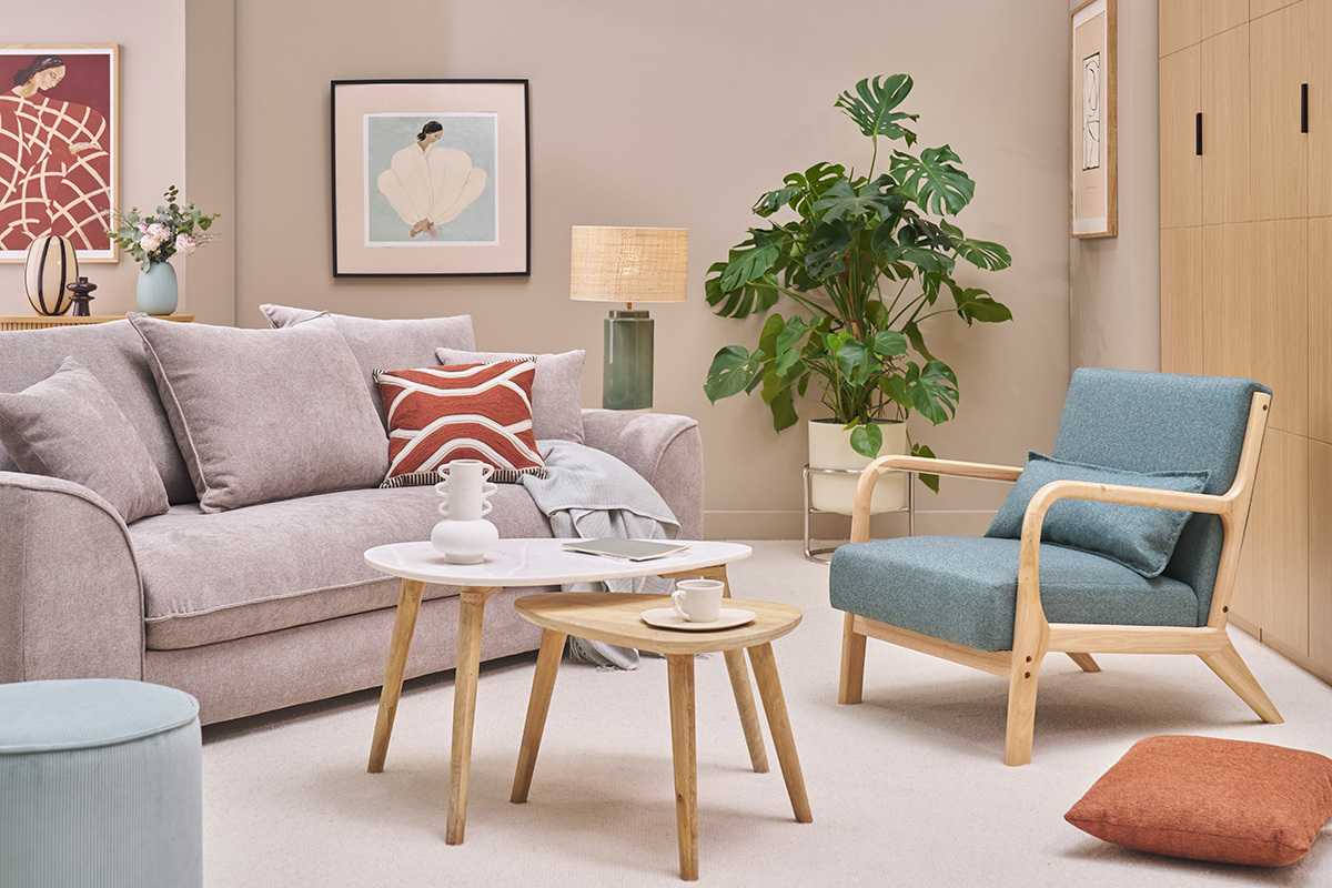 Fauteuil vert de gris et bois clair DERRY dans un salon scandinave avec canap�, tables et plantes.