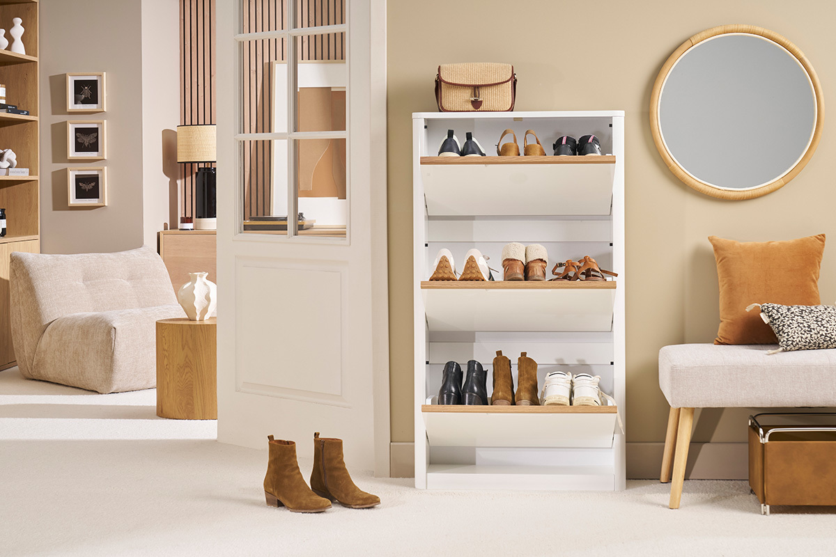 Vue de face d'un meuble  chaussures blanc  trois portes, avec des chaussures exposes.