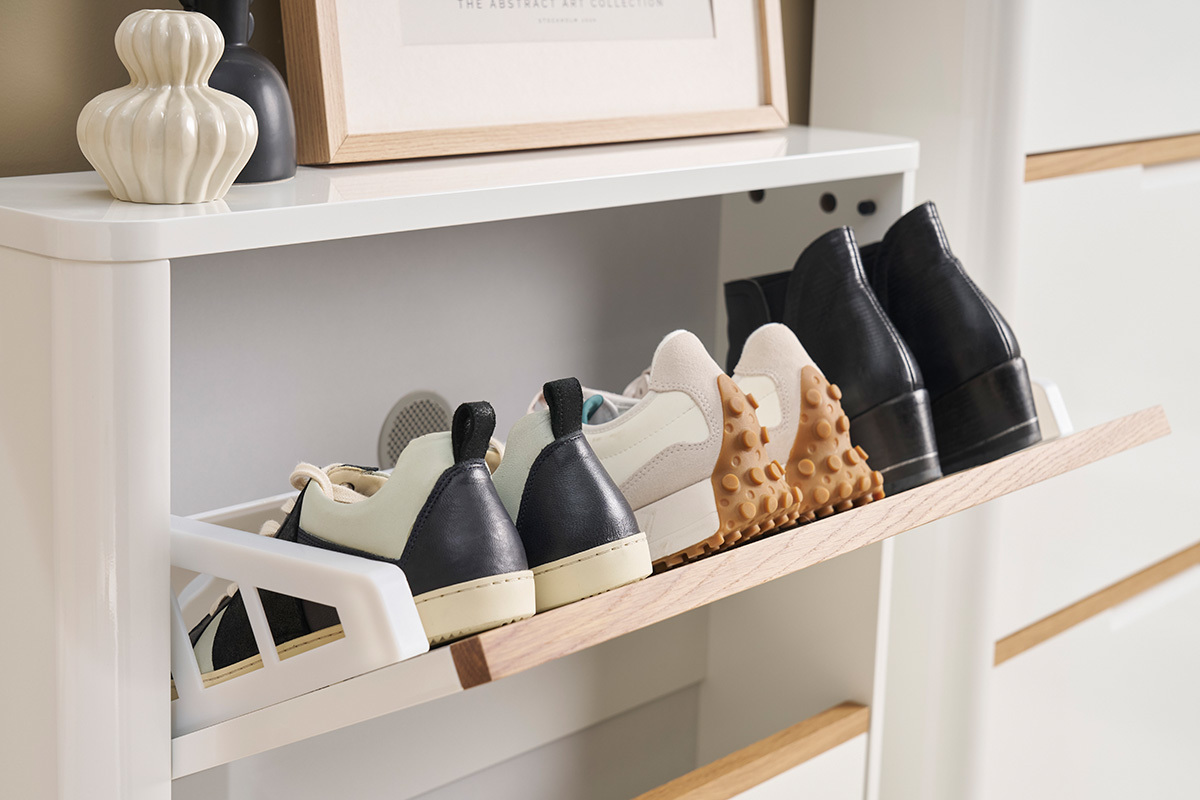 Meuble  chaussures blanc laqu avec abattant ouvert, chaussures ranges.