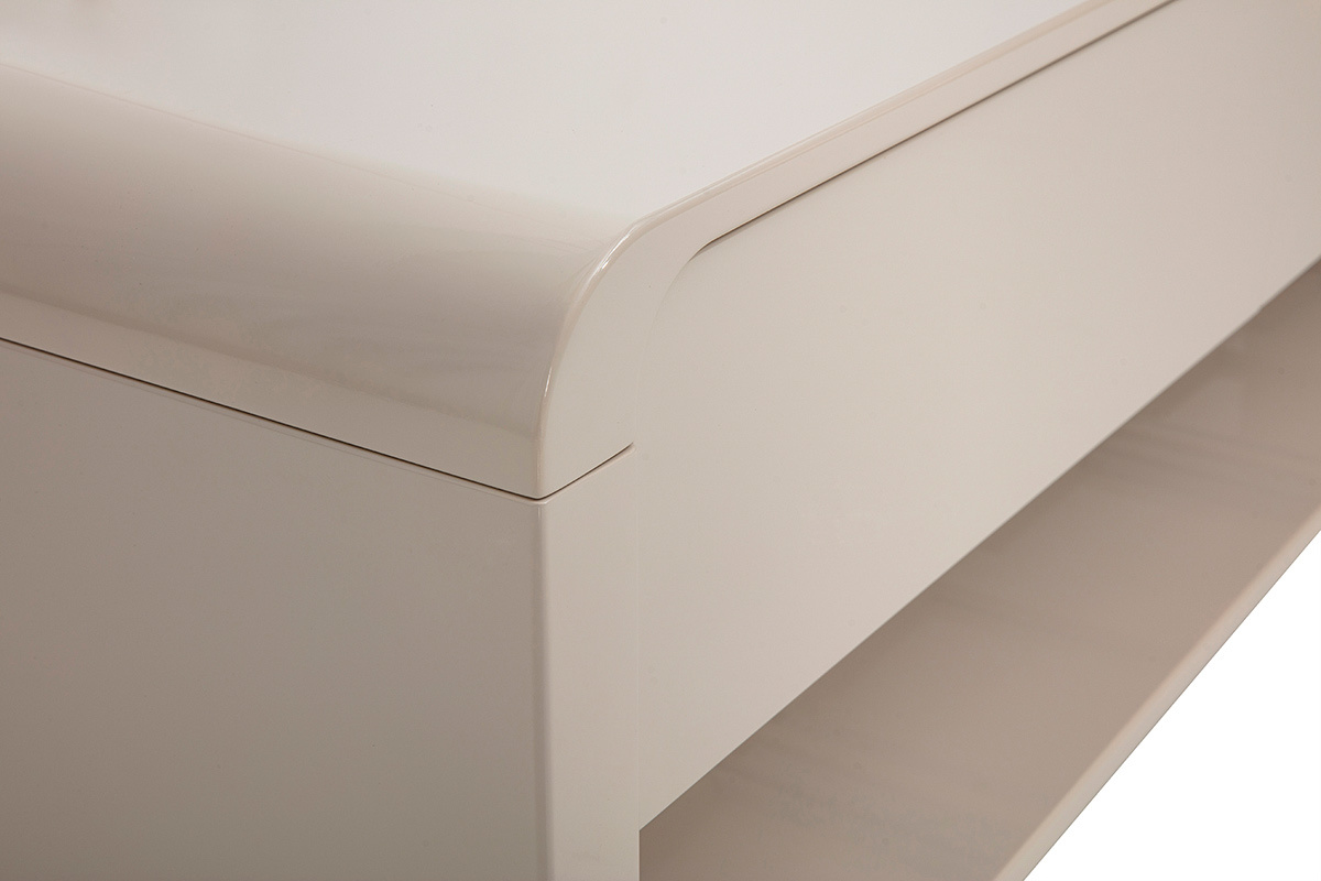 D�tail du meuble TV beige brillant avec coin arrondi et niche ouverte.