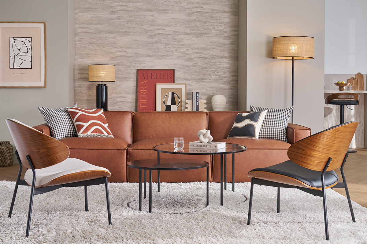 Canap en cuir marron SPLIT avec coussins, table basse en verre et fauteuils design.