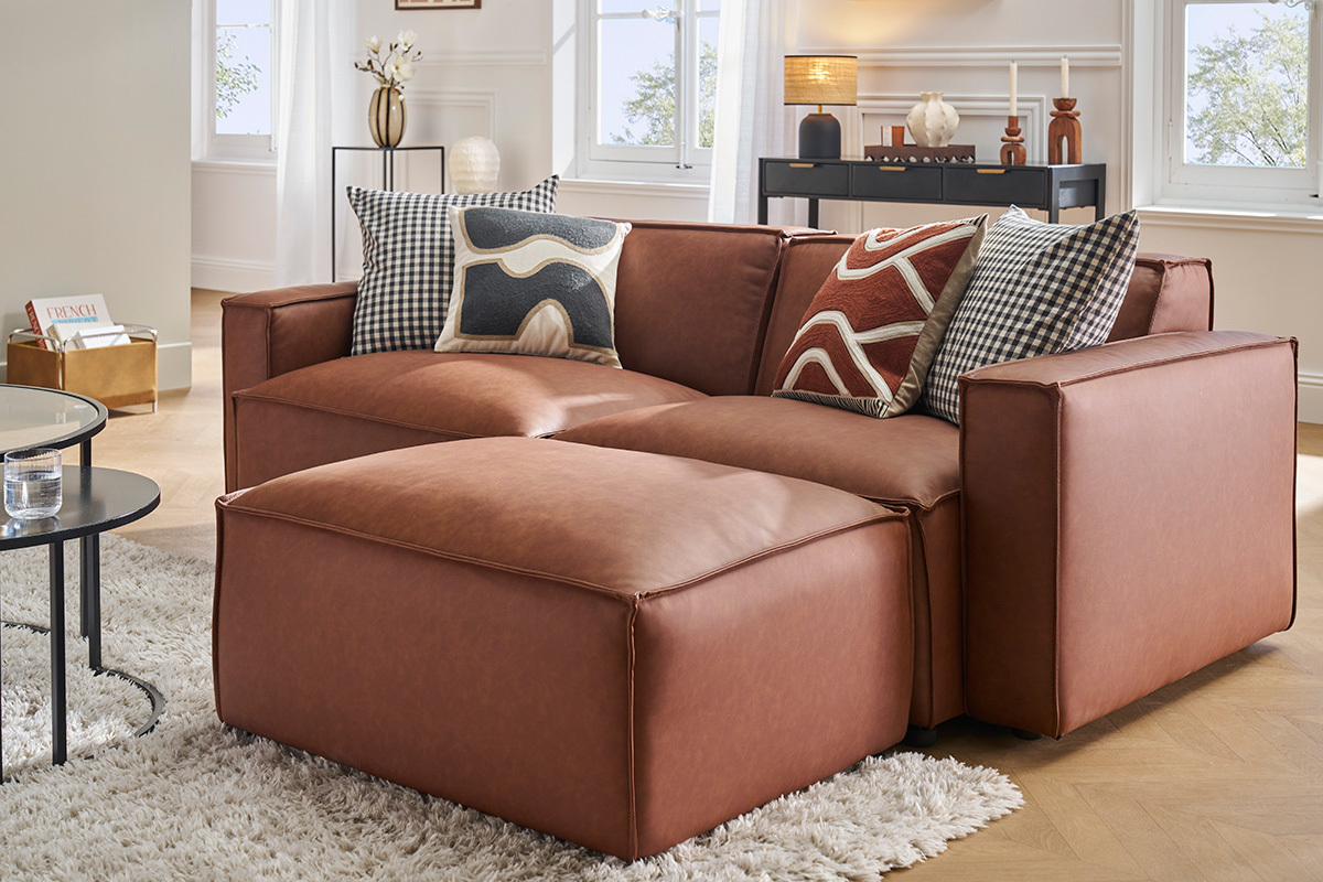 Pouf en cuir marron SPLIT devant canap assorti, vue de 3/4.