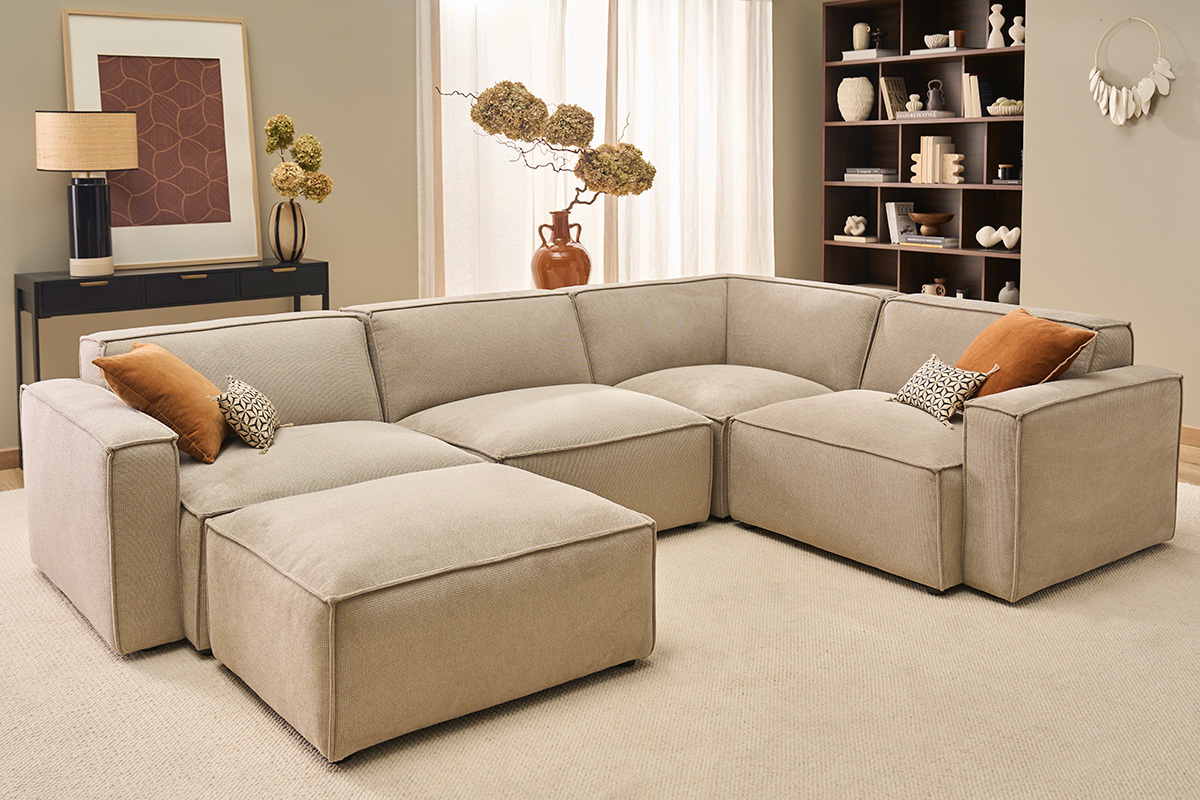 Salon avec canap� modulable beige en tissu chenille et pouf.