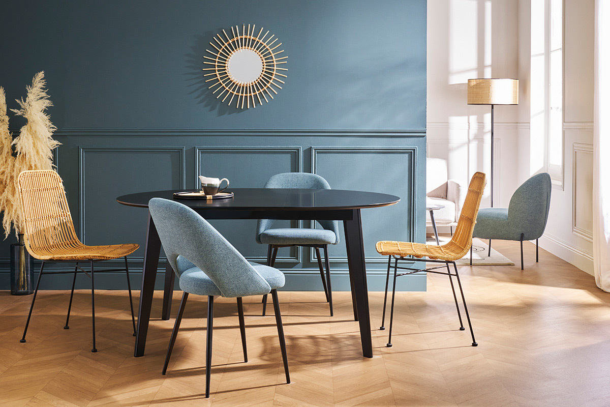 Table  manger ronde noire LEENA avec chaises design dans une salle  manger, vue de 3/4.