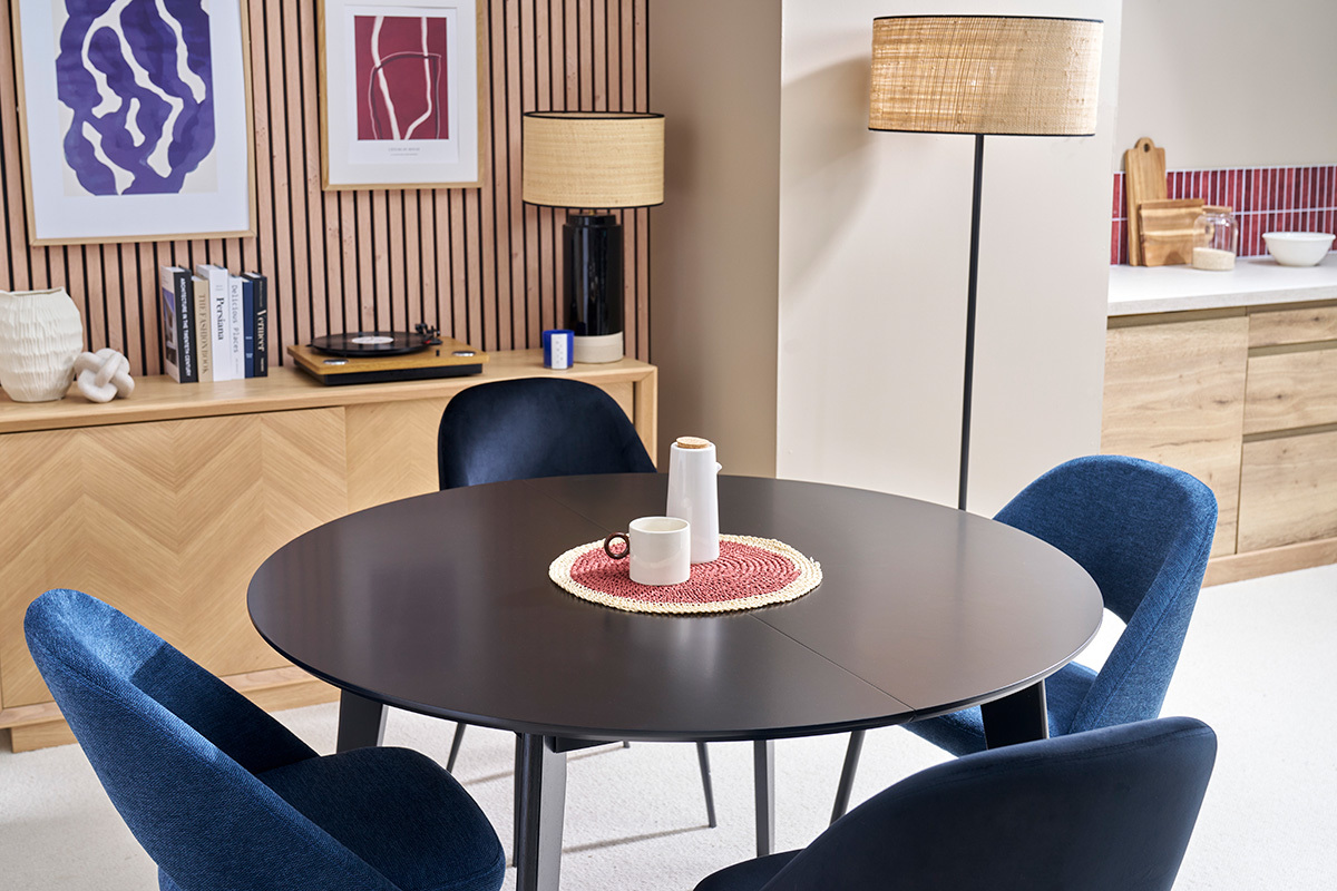 Table  manger ronde extensible noire LEENA avec chaises bleues.