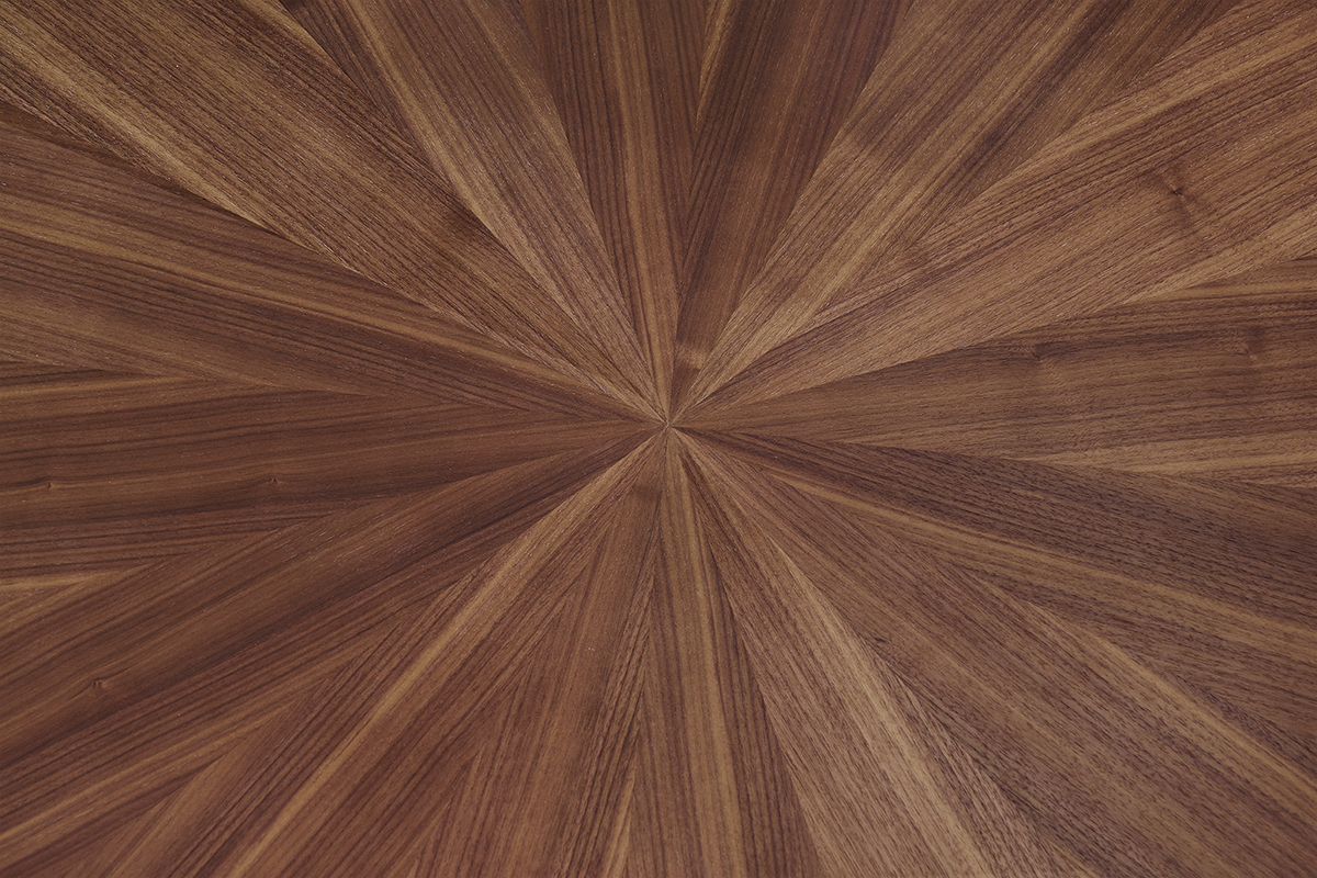 Gros plan sur le plateau ovale en placage noyer  motif  soleil  de la table DIELLI.