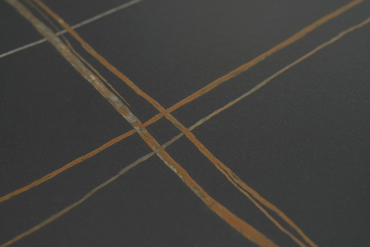 Dtail du plateau en cramique noire avec motifs ligneaires orangs de la table MALOU.