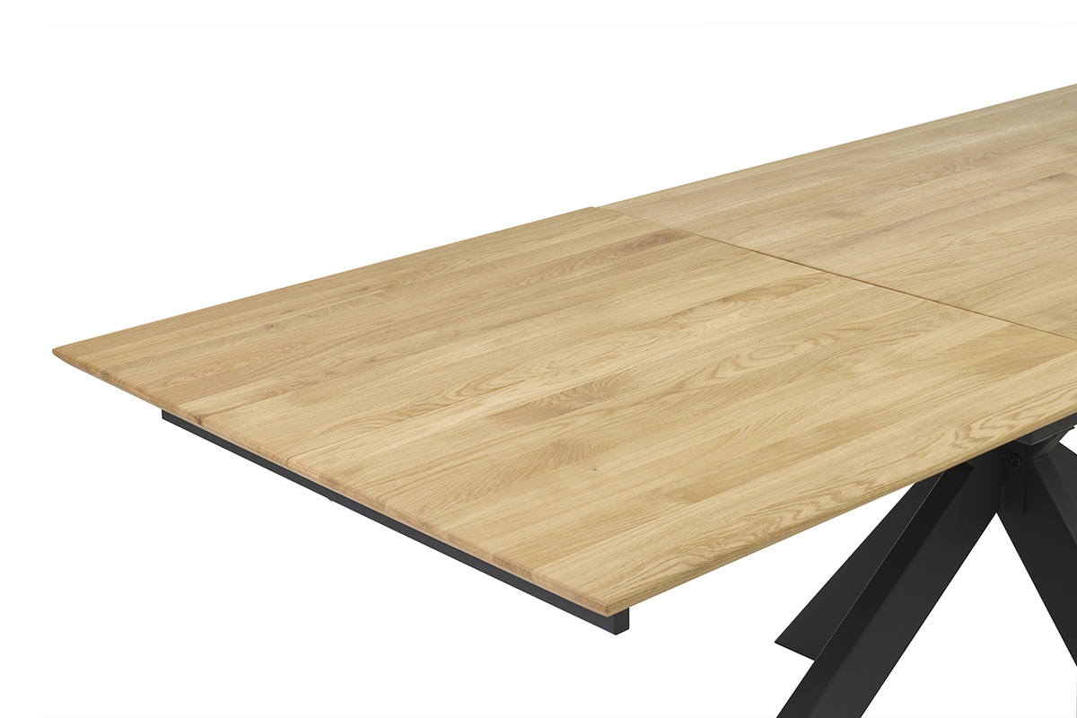 Table  manger extensible en chne clair vue en angle, rallonge intgre partiellement visible.