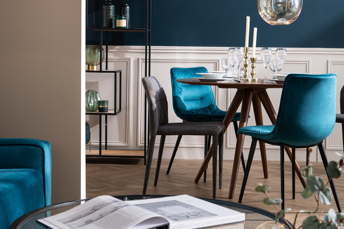 Table � manger ronde en bois fonc� D106 cm WALFORD avec des chaises design, vue de 3/4.