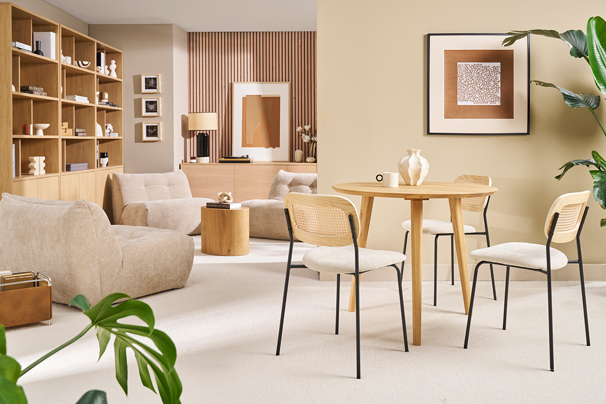 Table  manger ronde en bois clair avec quatre chaises, vue d'ensemble d'un salon moderne.