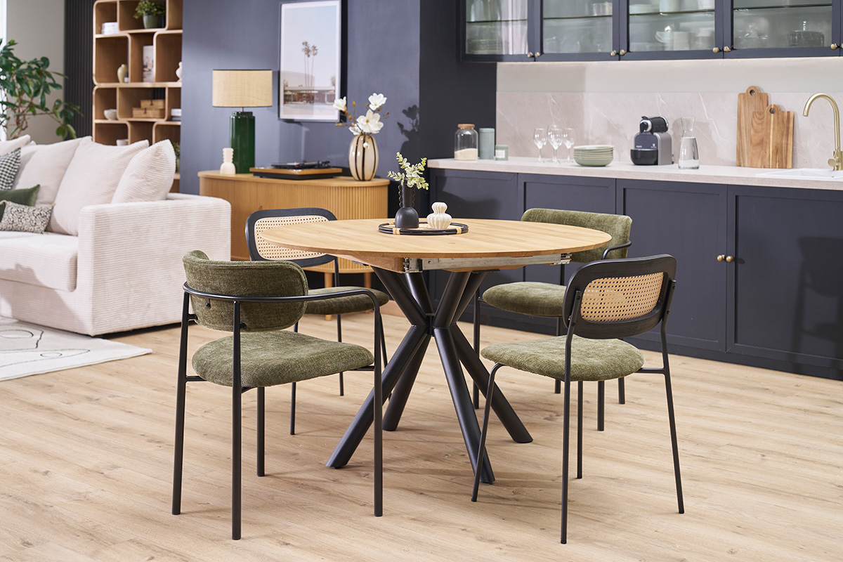 Table � manger ronde extensible en bois clair et m�tal avec chaises, vue d'int�rieur.