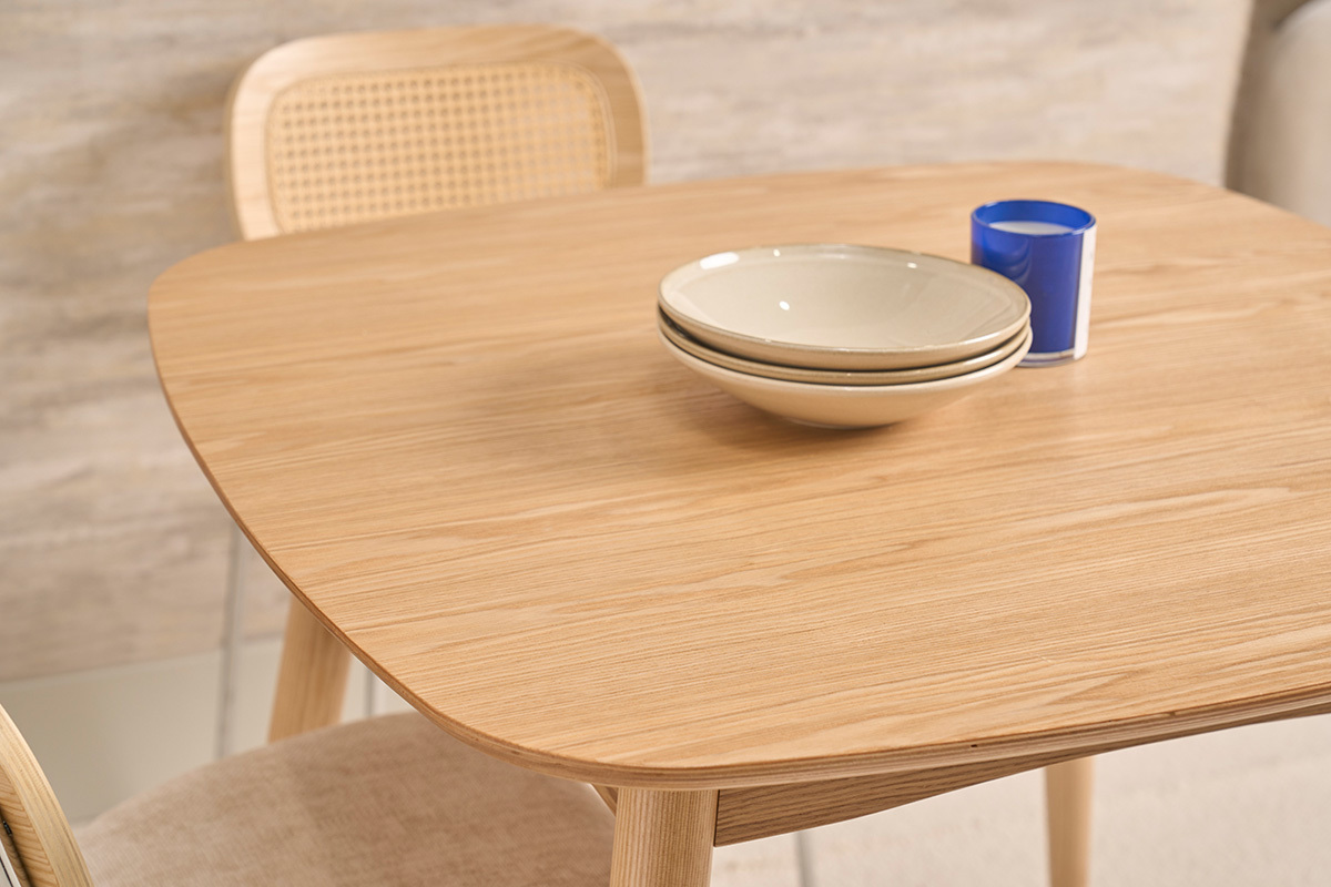 Table � manger scandinave carr�e en fr�ne naturel avec assiettes empil�es, vue en gros plan