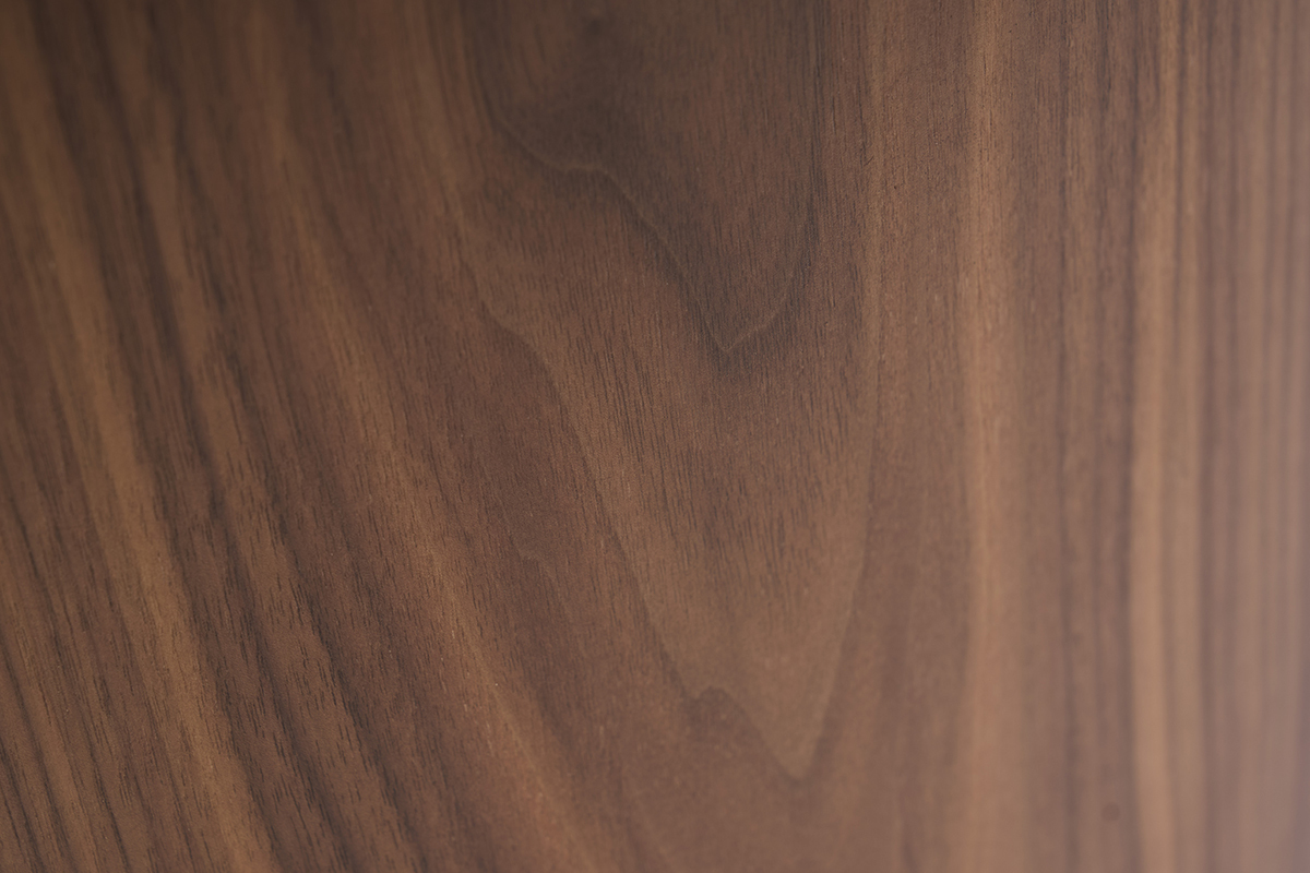Gros plan sur le veinage du bois fonc� noyer de la table basse design ovale ASSA.