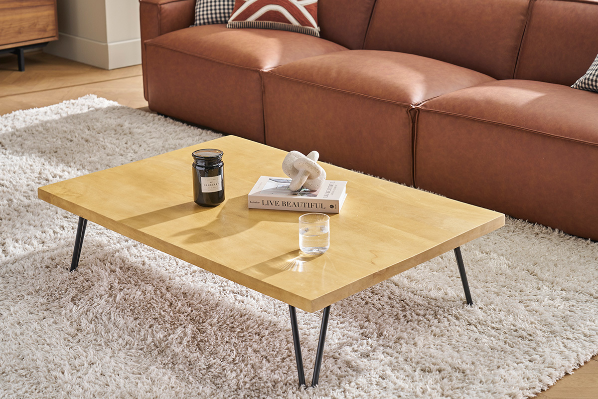 Table basse rectangulaire en bois de manguier avec pieds en mtal noir, vue d'angle, sur tapis blanc.