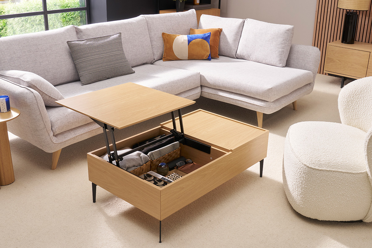 Table basse relevable bois clair avec plateau ouvert, rangements visibles, dans un salon moderne.