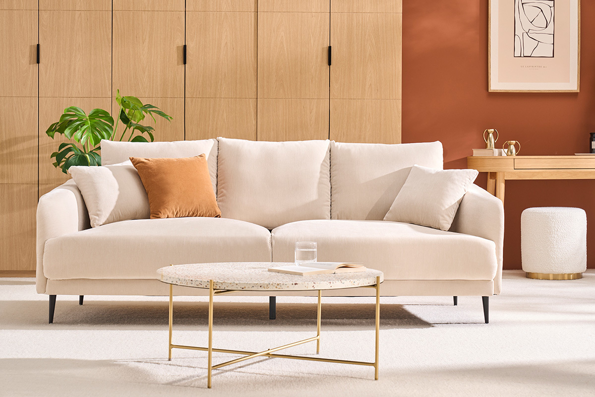 Table basse ronde en terrazzo et m�tal, vue de face, avec canap� et d�cor dans un salon moderne.