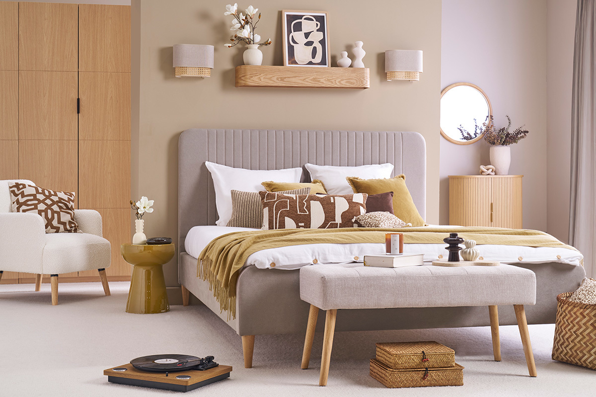 Chambre bronze, beige et bois clair avec banc et table d'appoint couleur bronze.