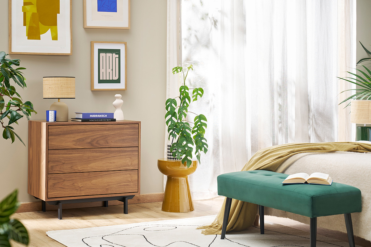 Table d'appoint ronde en m�tal �maill� bronze avec plante, dans chambre lumineuse.