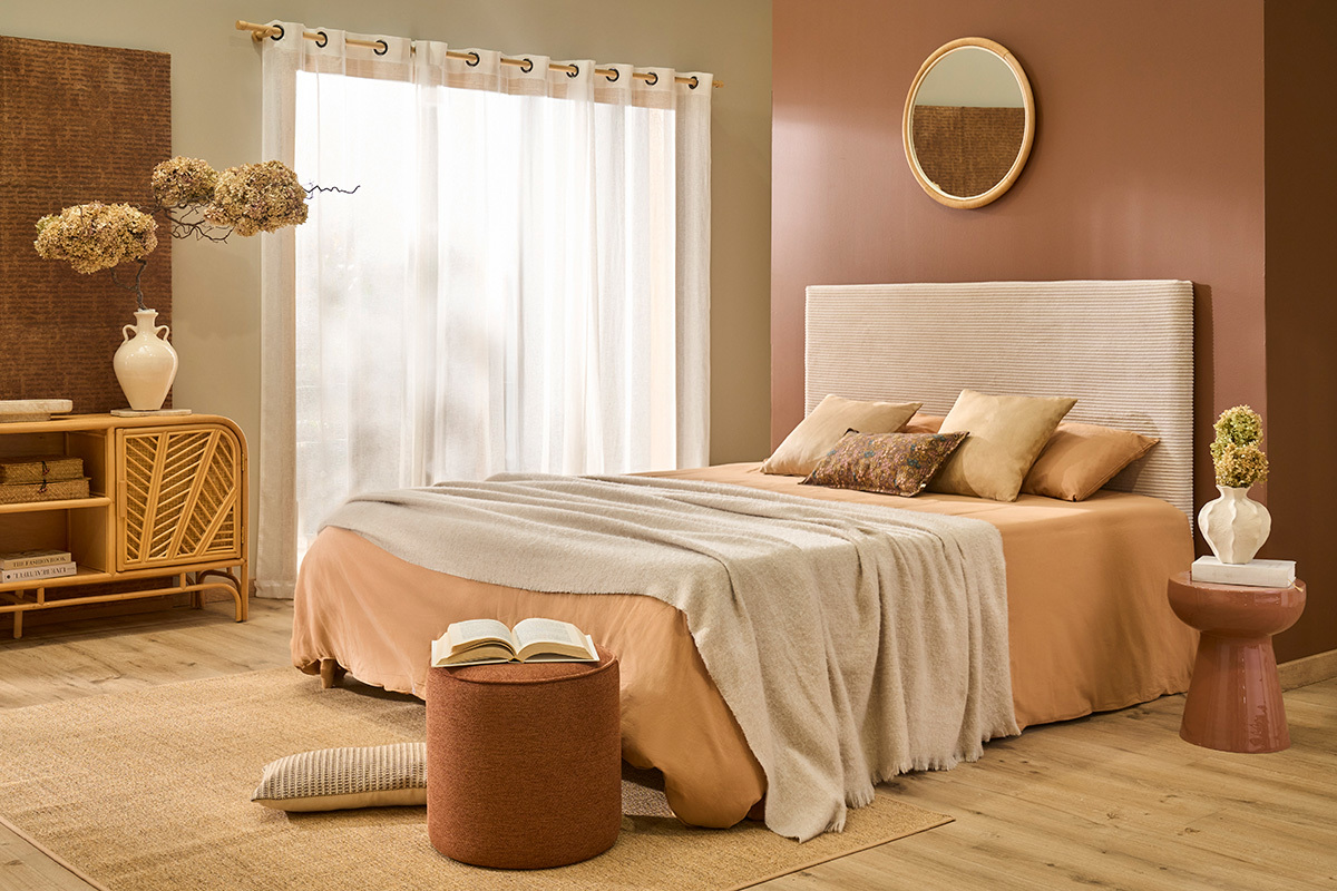 Chambre avec table d'appoint ronde en m�tal terracotta pr�s du lit.