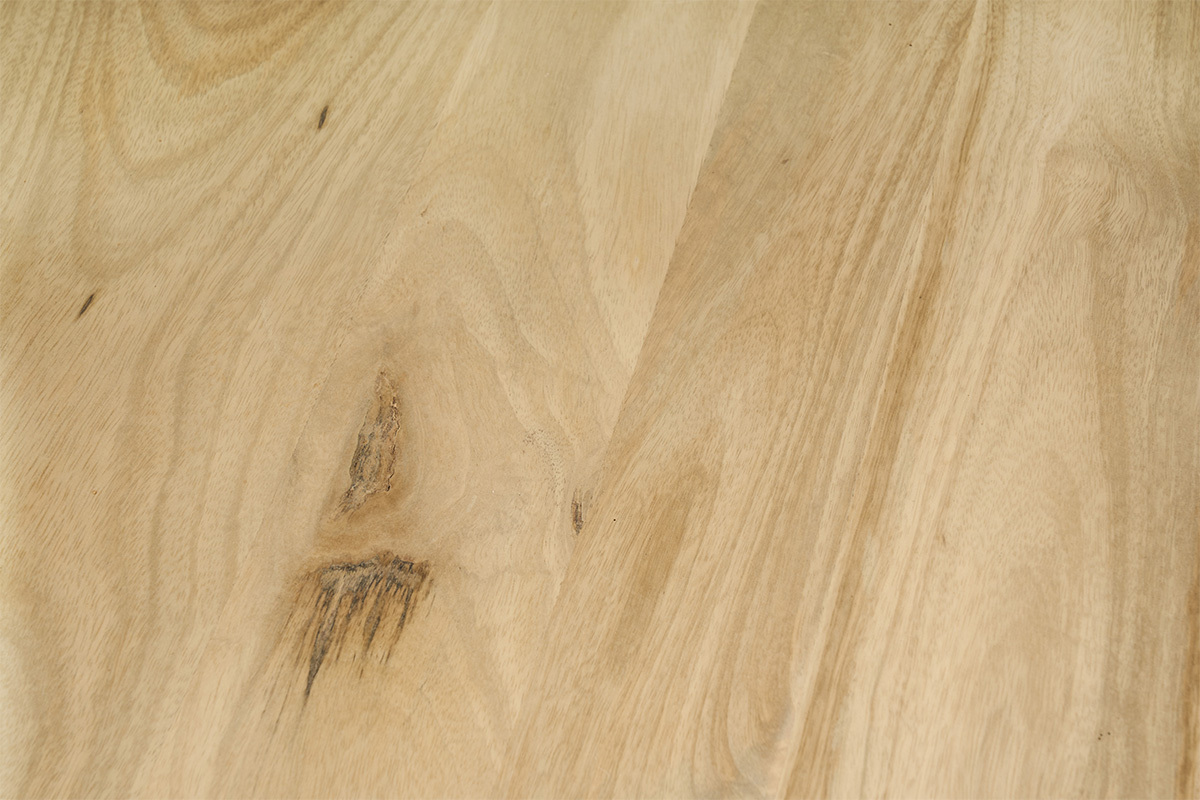 Gros plan du bois de manguier massif avec ses nuances naturelles.