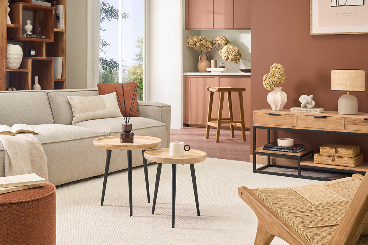Salon avec tables basses gigognes rondes en bois et m�tal noir, canap� beige et d�cor int�rieur chaleureux.
