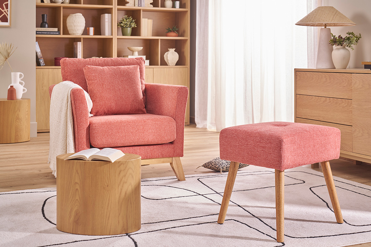 Salon avec fauteuil terracotta, tabouret assorti et table basse en bois.