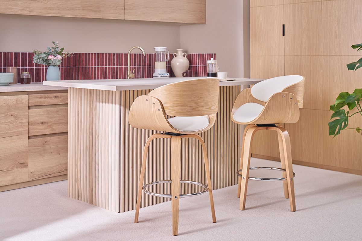 Deux tabourets de bar pivotants blancs et bois clair devant un �lot de cuisine.