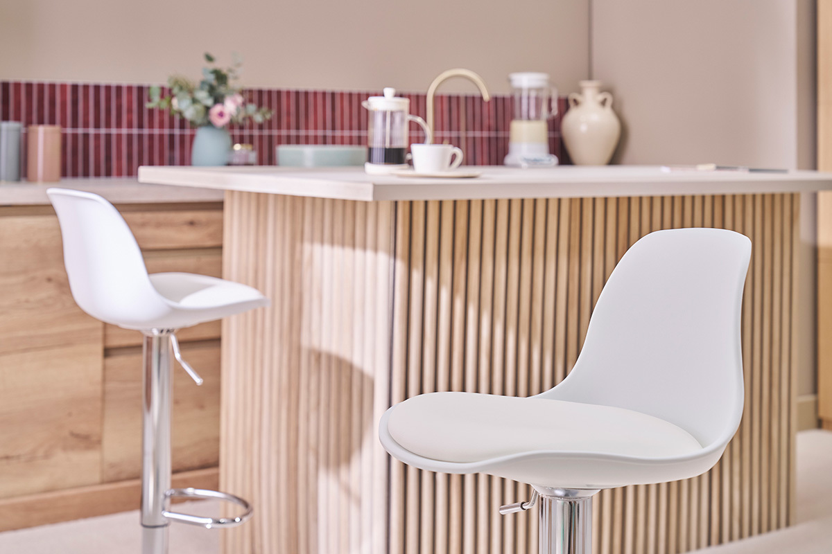 Tabourets de bar design blancs STEEVY devant un �lot de cuisine moderne.
