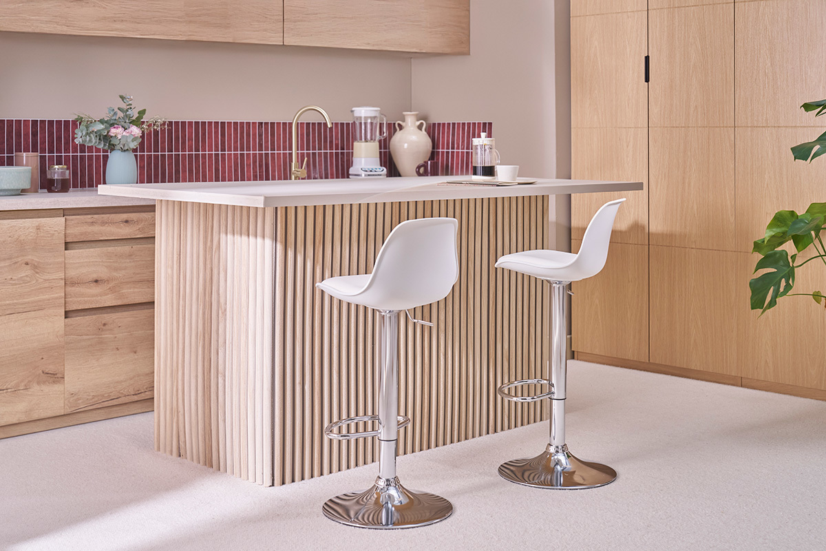 Tabourets de bar blancs avec pied chrom�, vue de c�t� dans une cuisine moderne.