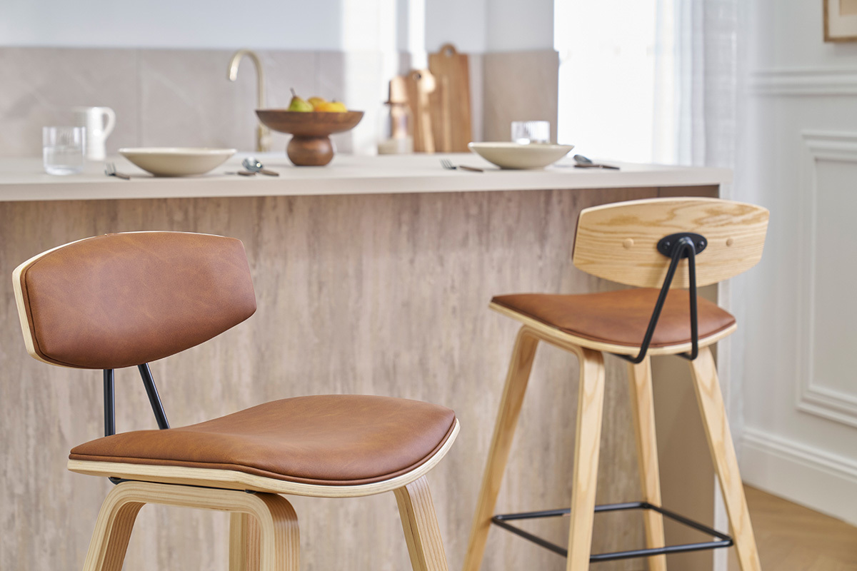 Deux tabourets de bar design marron et bois clair devant un comptoir de cuisine.
